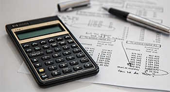 Bild mit Taschenrechner und Kugelschreiber